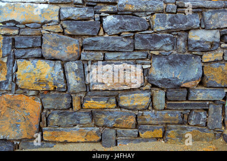 Stone texture of granite wall for creative background. Dark monolithic stones joined with cement in a single stone panel. Greek architecture, Bali, Cr Stock Photo
