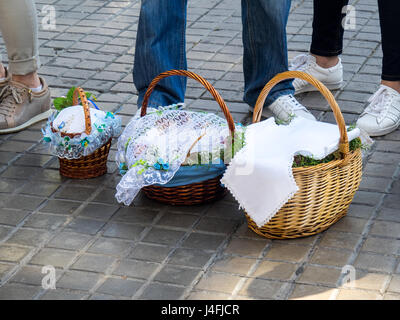 Three cane baskets covered with embroidered napkins with Easter offerings of eggs and cakes to celebrate the Russian Orthodox Easter. Stock Photo