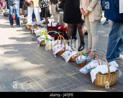 Families with their cane baskets covered with embroidered napkins with Easter offerings of eggs and cakes to celebrate the Russian Orthodox Easter. Stock Photo