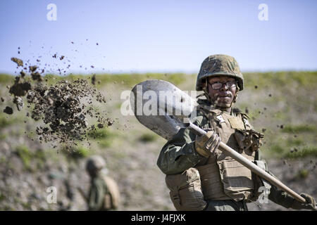 Marine Corps Pfc. Jason Taylor shovels dirt during airfield damage and repair training at Marine Corps Air Station Iwakuni, Japan Stock Photo