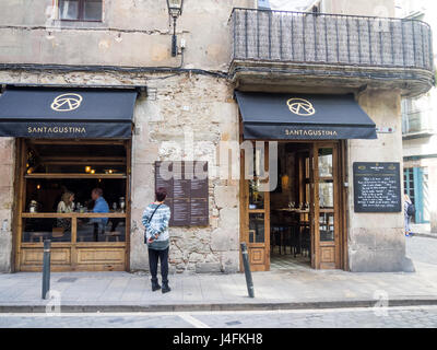 A woman reading the menu at Sant Agustina wine bar located in Placa de Sant Agusti Vell, Barcelona, Spain. Stock Photo