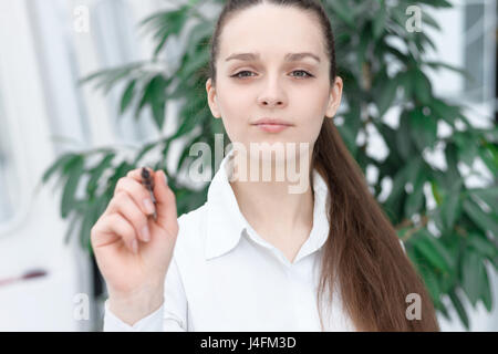 Business woman drawing a concept diagram on transparent screen by Pen Stock Photo