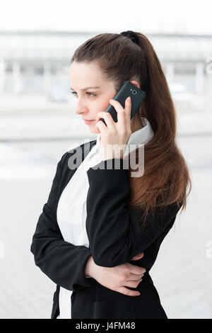 Young business woman talking on the mobile phone. Solving problems and business making Stock Photo
