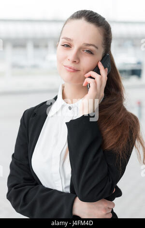 Young happy business woman talking on the mobile phone and smiling Stock Photo