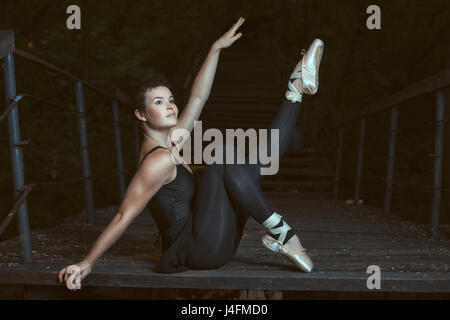Girl dancing in the park at night on the stairs. Stock Photo