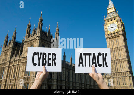 Hands holding signs protesting a computer cyber attack outside the Houses of Parliament at Westminster Palace in London, UK Stock Photo