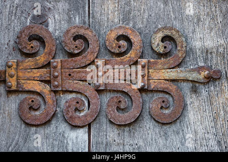 Rusty door hinge on an old weathered wooden door Stock Photo