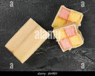 Almond Flavoured Battenberg Sponge Cake on a Black Slate Tile Stock Photo