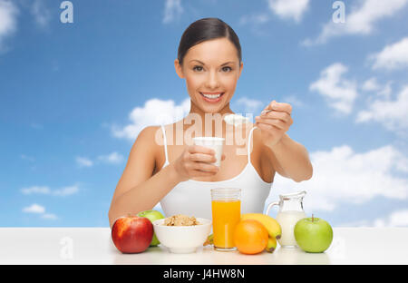 happy woman with fruits, cereals eating yogurt Stock Photo