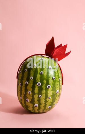 Freak watermelon wearing a crown on a pink background Stock Photo