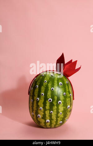 Freak watermelon wearing a crown on a pink background Stock Photo