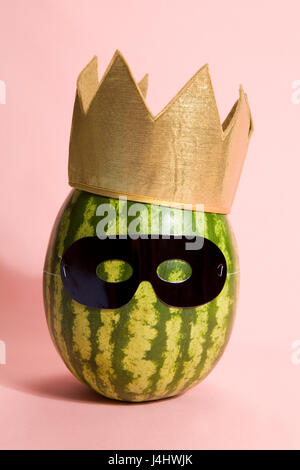 Superwatermelon wearing a black mask on a pink background Stock Photo