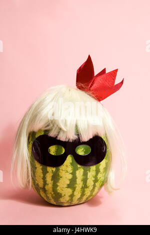 Superwatermelon wearing a black mask on a pink background Stock Photo