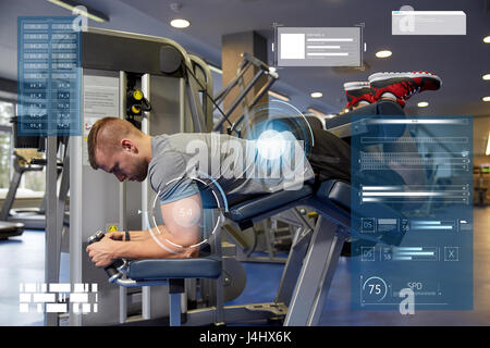 man flexing leg muscles on gym machine Stock Photo