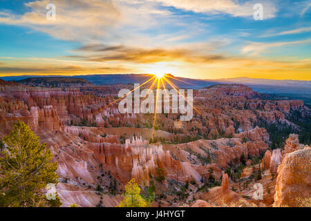 Sun rising above the horizon with sun rays at Bryce Canyon national Park in Utah Stock Photo