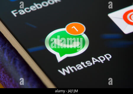 A closeup on the WhatsApp icon on a smartphone showing a new message is waiting, UK. Concept: social media, Meta, instant messaging, encryption Stock Photo