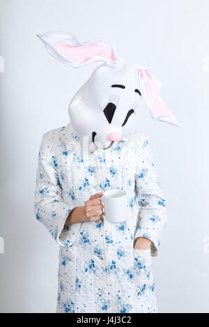 Rabbit difficult to wake in the morning Drinking a cup of coffee dressing-up clothes and conceptual parody Stock Photo