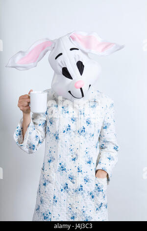 Rabbit difficult to wake in the morning Drinking a big cup of coffee dressing-up clothes and conceptual parody Stock Photo