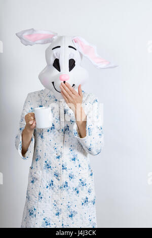 Rabbit difficult to wake in the morning He put his hand in front of his mouth after he have have spoken too hastily  dressing-up clothes and conceptua Stock Photo