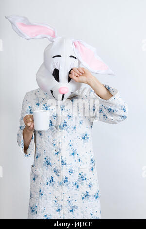 Rabbit difficult to wake in the morning Drinking a cup of coffee dressing-up clothes and conceptual parody Stock Photo