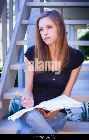 Student thinking with notebook and pencil Stock Photo