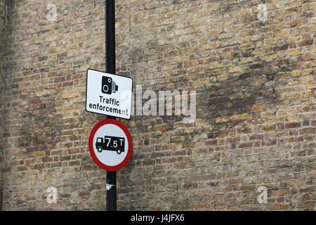 Traffic enforcement and weight limit sign against brick wall Stock Photo