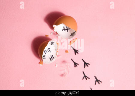 The counting of the days on a broken egg with footprint on a pink and blue background Stock Photo