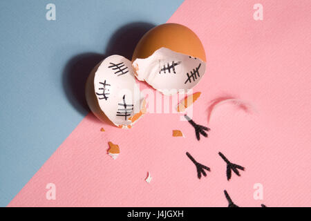 The counting of the days on a broken egg with footprint on a pink and blue background Stock Photo