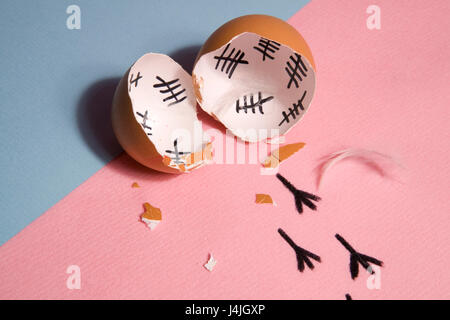 The counting of the days on a broken egg with footprint on a pink and blue background Stock Photo