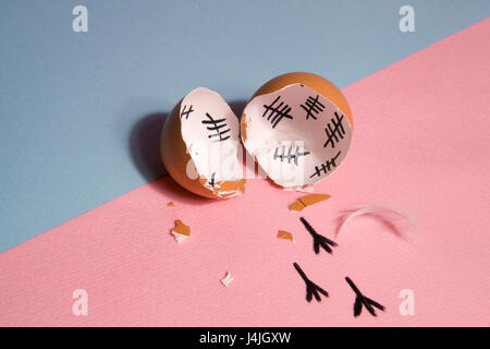 The counting of the days on a broken egg with footprint on a pink and blue background Stock Photo