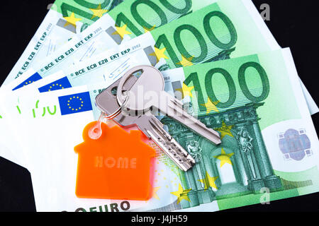House keys with a keychain on top on 100 Euro notes studio shot Stock Photo