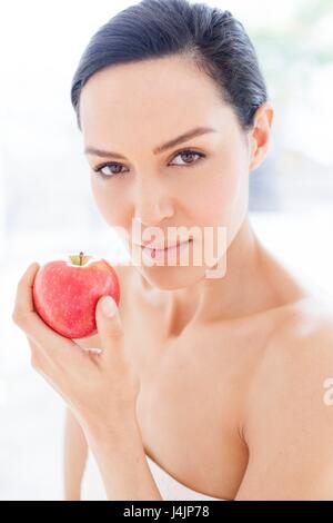 Young woman holding camera and looking down with smile Stock Photo - Alamy