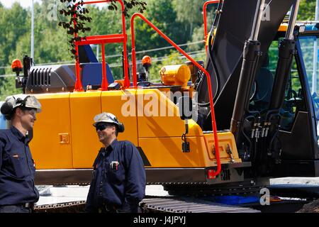 Engineers on construction site with heavy machinery. Stock Photo