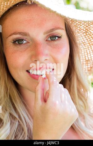 Young woman taking tablet, smiling. Stock Photo