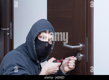 thief opening lock on door Stock Photo