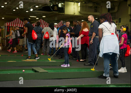 161001-N-EH855-010  ATLANTIC OCEAN (Oct. 1, 2016) Sailors and their families play mini golf in the hangar bay of the aircraft carrier USS George Washington (CVN 73) during a Friends and Family Day Cruise. George Washington is homeported in Norfolk after serving seven years in Yokosuka, Japan. (U.S. Navy photo by Petty Officer 3rd Class Bryan Mai/Released)