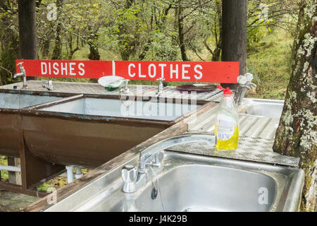 washing dishes and clothes by hand - small basic campsite washing up facilities - Red Squirrel campsite, Glencoe, Scotland, UK Stock Photo