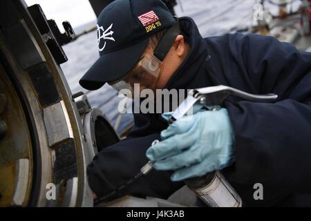 Fire Controlman performs maintenance on a SVTT torpedo tube aboard USS Donald Cook (DDG 75) while forward-deployed to Rota, Spain during 6th Fleet naval operations. Stock Photo