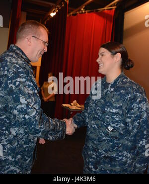 170208-N-SP496-006 SILVERDALE, Wash. (Feb. 8, 2017) – Capt. Alan Schrader, Naval Base Kitsap (NBK) commanding officer, presents Aviation Ordnanceman 3rd Class Paige Gormley with a command coin during an all-hands call held at the NBK-Bangor Theater. More than 30 awards and decorations were bestowed to NBK personnel during the event. (U.S. Navy photo by Petty Officer 3rd Class Jane Wood/Released) Stock Photo