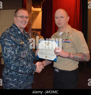 170208-N-SP496-023 SILVERDALE, Wash. (Feb. 8, 2017) – Capt. Alan Schrader (left), Naval Base Kitsap (NBK) commanding officer, presents Culinary Specialist 1st Class Pete Kowall with the Navy and Marine Corps Achievement Medal during an all-hands call held at the NBK-Bangor Theater. More than 30 awards and decorations were bestowed to NBK personnel during the event. (U.S. Navy photo by Petty Officer 3rd Class Jane Wood/Released) Stock Photo