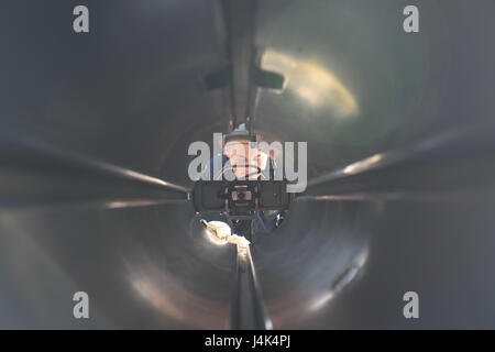 Fire Controlman performs maintenance on a torpedo tube aboard USS Porter (DDG 78) during operations in the Mediterranean Sea, forward-deployed to Rota, Spain, supporting U.S. 6th Fleet maritime security. Stock Photo