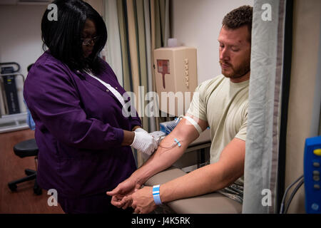 A medical assistant draws blood from Staff Sgt. Nicholas Worley, 23d Civil Engineer Squadron electrical systems craftsman, during an appointment, April 18, 2017, in Valdosta, Ga. In January 2012 Worley was diagnosed with Chronic Myelogenous Leukemia, an uncommon form of blood-cell cancer that starts in the blood-forming bone marrow cells. He’s currently in remission and goes to the cancer center every three months to ensure his treatment is still working. (U.S. Air Force Photo by Senior Airman Janiqua P. Robinson) Stock Photo