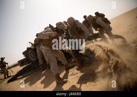 CAMP BUEHRING, Kuwait (April 23, 2017)— U.S. Marine Lance Cpl. Dashawn Williams of Queens, New York, a field artillery canon crewman assigned to Fox Battery, 3rd Battalion, 6th Marine Regiment, 24th Marine Expeditionary Unit (MEU), digs a hole with his fellow Marines to emplace the spades of an M777 A2 howitzer at an indirect firing range outside Camp Buehring, Kuwait April 23, 2017. The Marines are in Kuwait for a sustainment training evolution.  The 24th MEU is currently deployed with the Bataan Amphibious Ready Group in support of maritime security operations designed to reassure allies and Stock Photo