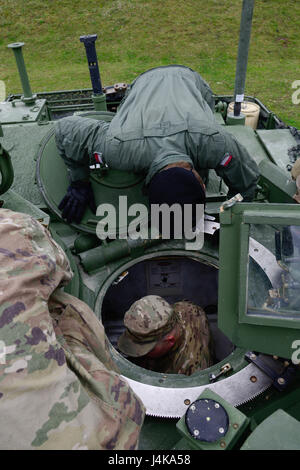 A U.S. Soldier, assigned to 1st Battalion, 66th Armor Regiment, 3rd Armor Brigade Combat Team, 4th Infantry Division, shows a Polish soldier the inside of a M1 Abrams Main Battle Tanks during the Strong Europe Tank Challenge (SETC) opening ceremony, at Grafenwoehr Training Area, Germany, May 07, 2017. The SETC is co-hosted by U.S. Army Europe and the German Army, May 7-12, 2017. The competition is designed to project a dynamic presence, foster military partnership, promote interoperability, and provides an environment for sharing tactics, techniques and procedures. Platoons from six NATO and p Stock Photo