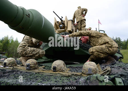 Ukrainian soldiers inspect a M1 Abrams Main Battle Tank, operated by U.S. Soldiers, assigned to 1st Battalion, 66th Armor Regiment, 3rd Armor Brigade Combat Team, 4th Infantry Division, during the Strong Europe Tank Challenge (SETC) opening ceremony, at Grafenwoehr Training Area, Germany, May 07, 2017. The SETC is co-hosted by U.S. Army Europe and the German Army, May 7-12, 2017. The competition is designed to project a dynamic presence, foster military partnership, promote interoperability, and provides an environment for sharing tactics, techniques and procedures. Platoons from six NATO and  Stock Photo