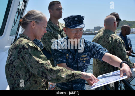 170508-N-WC492-062 YOKOSUKA, Japan (May 8, 2017) Vice Adm. Mary Jackson, commander, Navy Installations Command, and Capt. Jeffrey Kim, commander, Fleet Activities Yokosuka, discuss base-related issues during a tour of Yokosuka’s harbor.  Fleet Activities Yokosuka provides, maintains, and operates base facilities and services in support of 7th Fleet's forward-deployed naval forces, 71 tenant commands, and more than 26,000 military and civilian personnel.  (U.S. Navy photo by Daniel A. Taylor/Released) Stock Photo