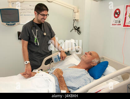 Jonathan Serna, registered nurse, Surgical Ward, William Beaumont Army Medical Center, checks on Henrie Schneider, WBAMC inpatient, during Schneider's stay at WBAMC's Surgical Ward, April 11. William Beaumont Army Medical Center recently exceeded U.S. Army Medical Command's benchmark for inpatient satisfaction scores as measured by the Tricare Inpatient Satisfaction Survey (TRISS). Stock Photo