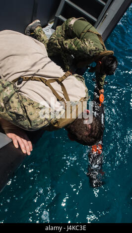 Sailors assigned to Explosive Ordnance Disposal Mobile Unit 5 (EODMU5) Platoon 142 deploy an unmanned underwater vehicle from a Coastal Riverine Group 1 Detachment Guam MK VI patrol boat off the coast of Saipan May 9, 2017. EODMU5 is currently testing its ability to deploy assets from various platforms, including helicopters and patrol boats, to increase its adaptive interoperability. EODMU5 conducts mine countermeasures, improvised explosive device operations, renders safe explosive hazards and disarms underwater explosives such as mines. (U.S. Navy Combat Camera photo by Mass Communication S Stock Photo
