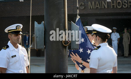 Lt. jg. Tigran Sadoian, Lt. jg. Caylin Schultz, and Ens. Sara Phipps, nurses, perform morning colors during a ceremony celebrating Nurses Week, May 10, 2017. NHCL Officers, Sailors and Civilians gathered in formation to observe the ceremony. (U.S. Navy Photo by Mass Communication Specialist 3rd Class Nicolas N. Lopez/ Released) Stock Photo