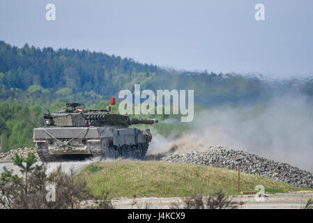 An Austrian Leopard 2A4 tank fires at its target during the Strong Europe Tank Challenge (SETC), at the 7th Army Training Command Grafenwoehr Training Area, Germany, May 11, 2017. The Strong Europe Tank Challenge (SETC) is co-hosted by U.S. Army Europe and the German Army, May 7-12, 2017. The competition is designed to project a dynamic presence, foster military partnership, promote interoperability, and provides an environment for sharing tactics, techniques and procedures. Platoons from six NATO and partner nations are in the competition. (U.S. Army photo by Spc. Nathanael mercado) Stock Photo